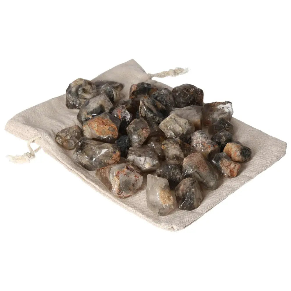 Collection of premium Tumbled Lodolite gemstones on a soft beige cloth, embodying elegance and mysticism from Sylvia Crystals.