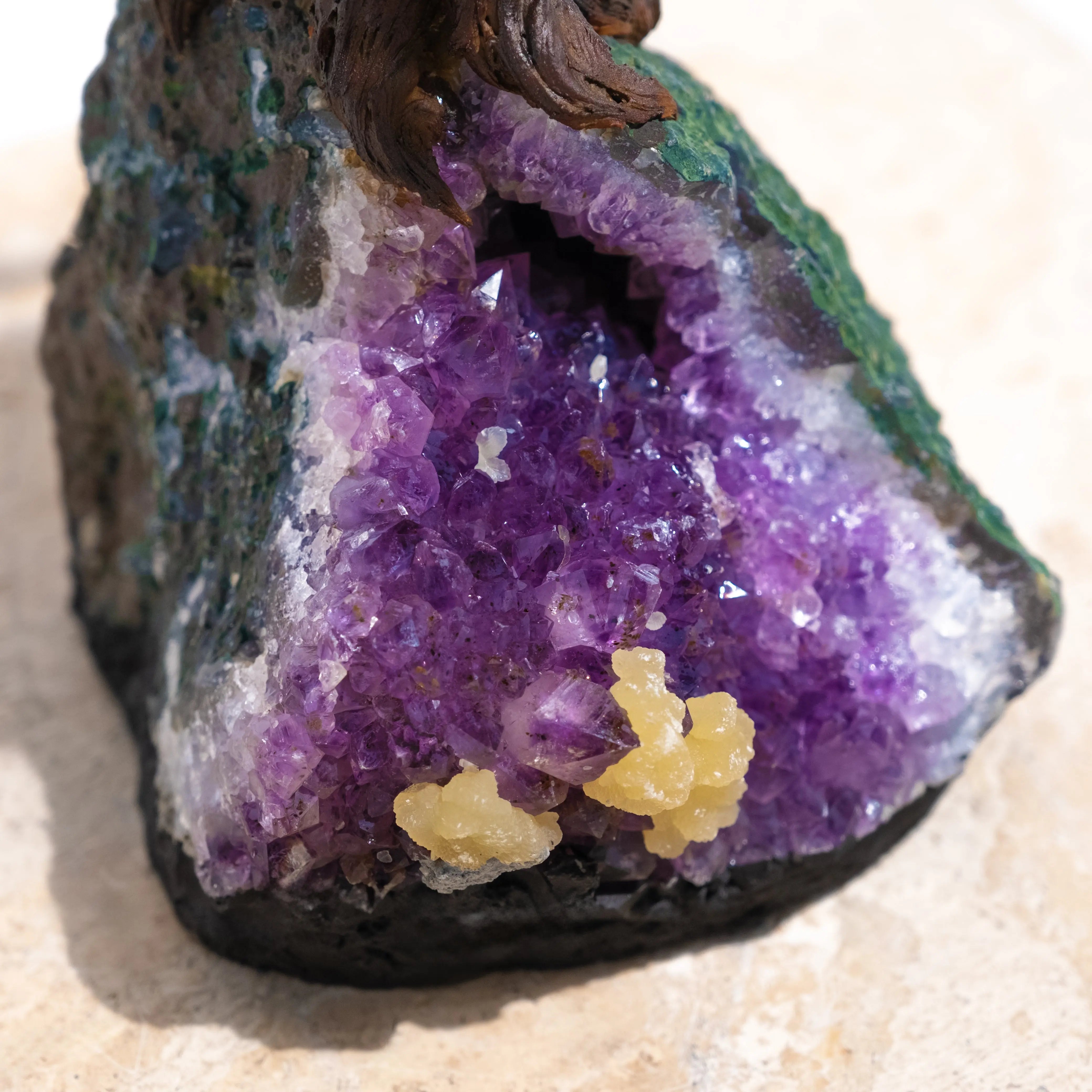 Amethyst geode with vivid purple crystals and green outer layer, showcasing intricate gemstone formations.