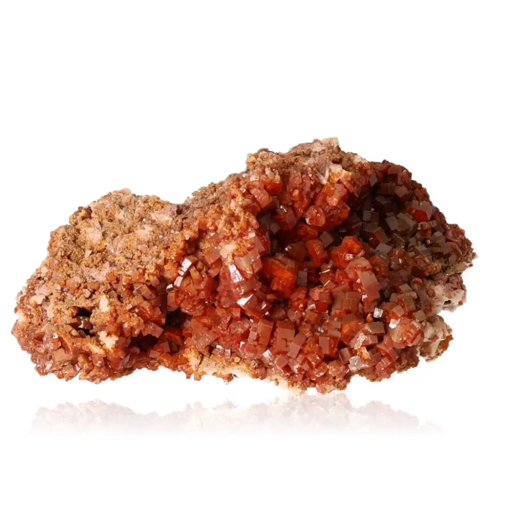 Vibrant red-orange vanadinite druze crystal, known for creativity and focus, showcasing its unique mineral formation against a white background.