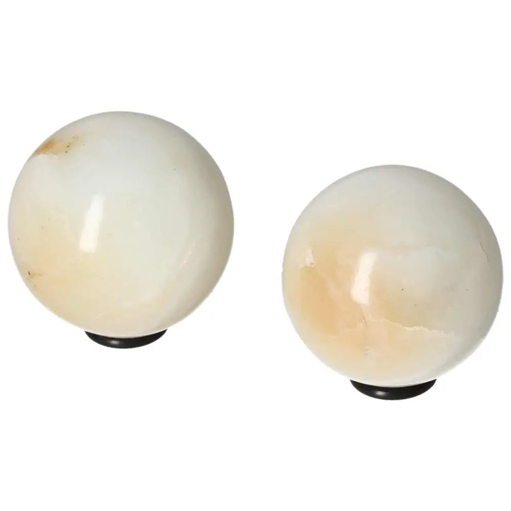 Pair of white onyx spheres, known for enhancing determination, self-discipline, and overcoming life's challenges.