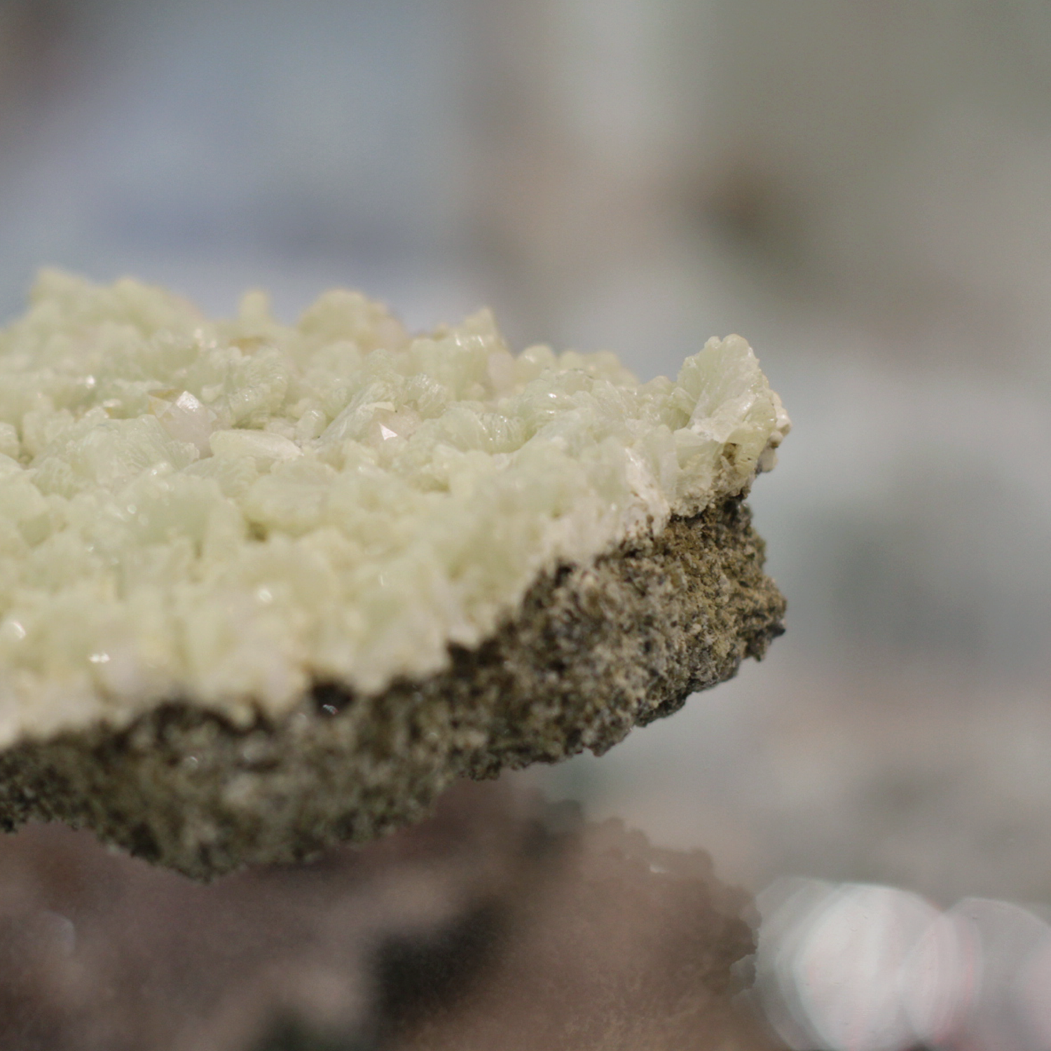 Raw prehnite gemstone cluster with pale green hues for healing and intuition enhancement.
