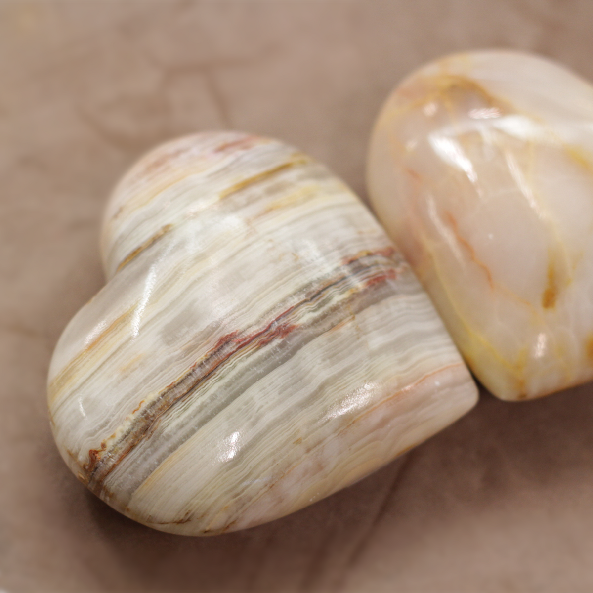 Polished onyx sphere gemstone showcasing natural earthy tones and patterns for strength and protection.