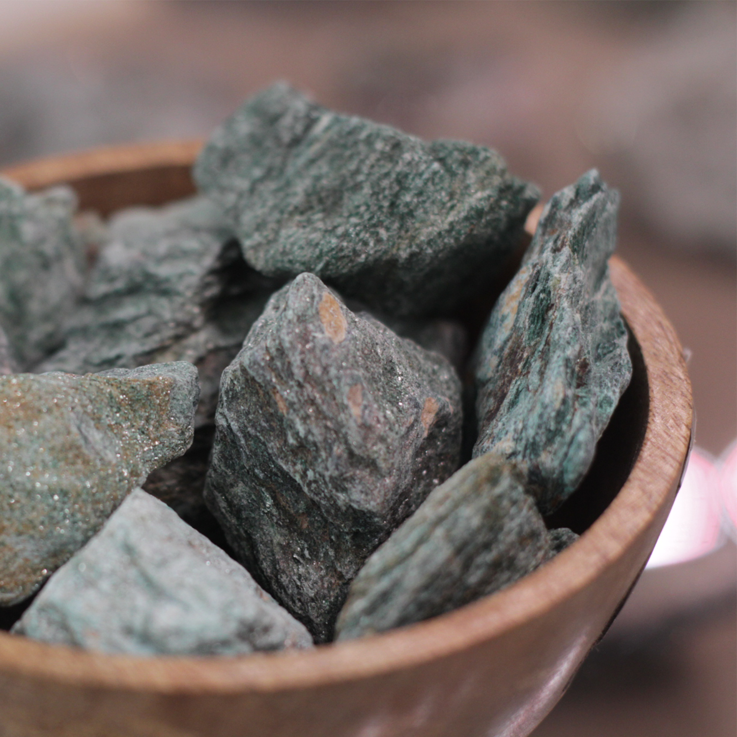 Fuchsite stone on stand, showcasing vibrant green hues for emotional healing and rejuvenation, known as the Healer's Stone.
