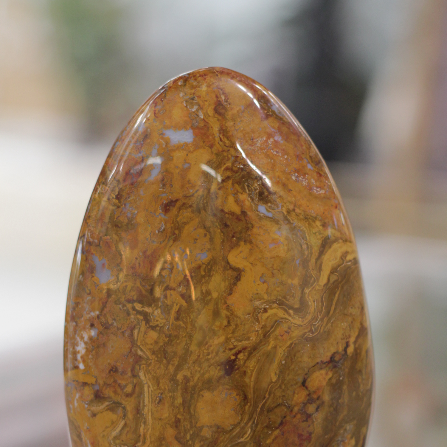 Polished Nellite gemstone showcasing golden Tiger's Eye and blue Pietersite hues, symbolizing courage and transformation.