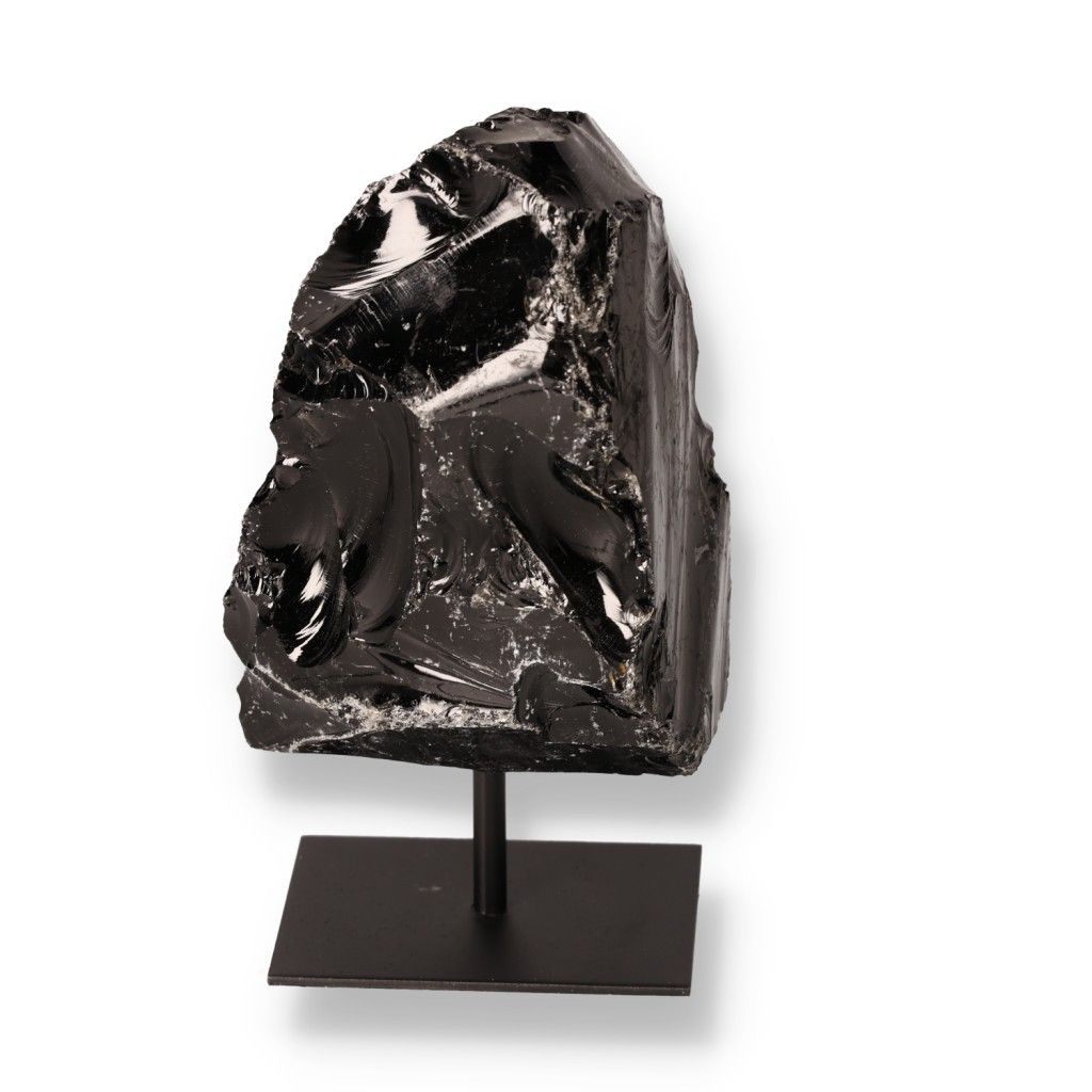 Shiny black obsidian on display stand showcasing its natural volcanic glass texture and sharp edges.