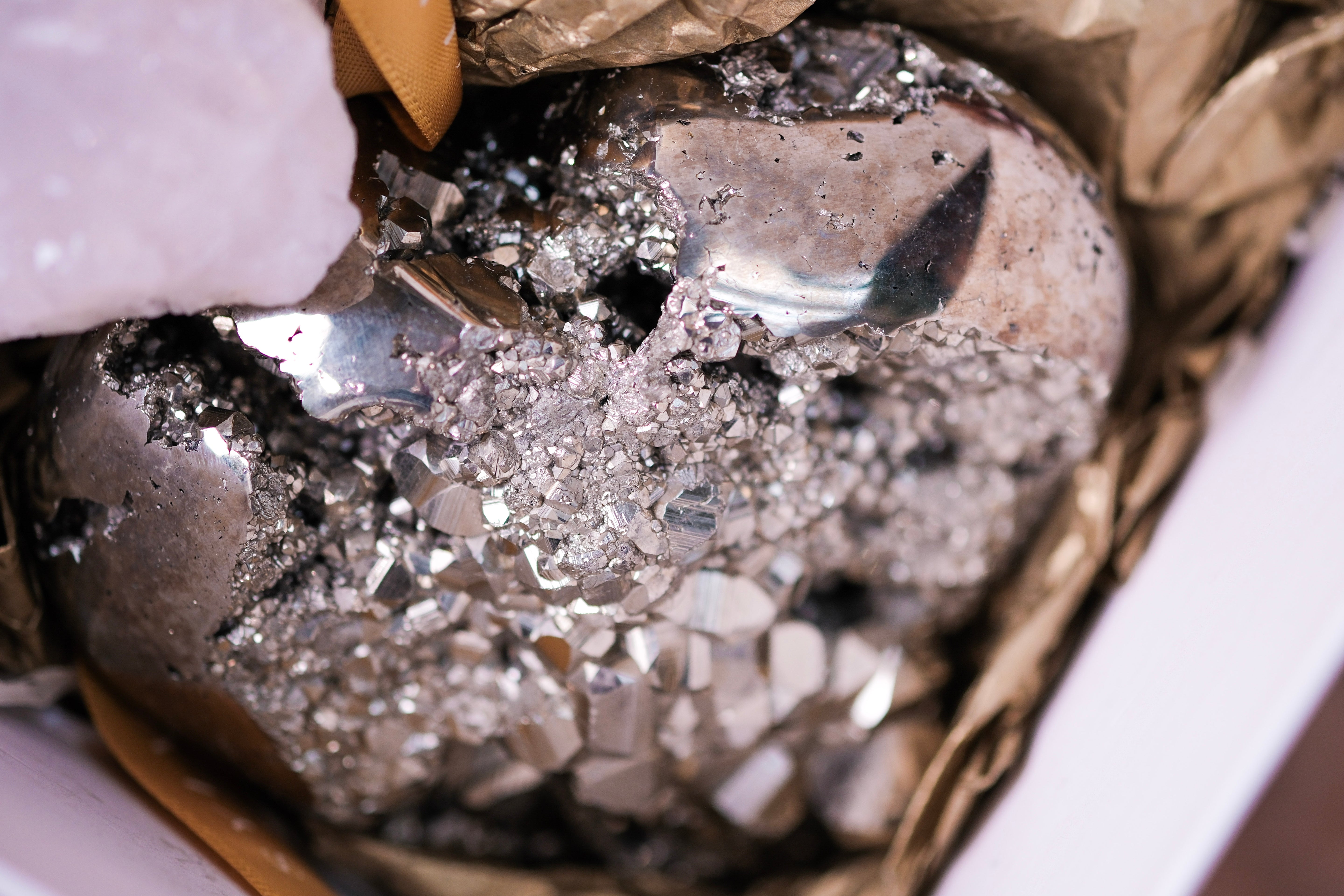 Pyrite heart surrounded by crystals from Sylvia Crystals' Wealth and Abundance Deluxe Christmas Box for holiday prosperity.