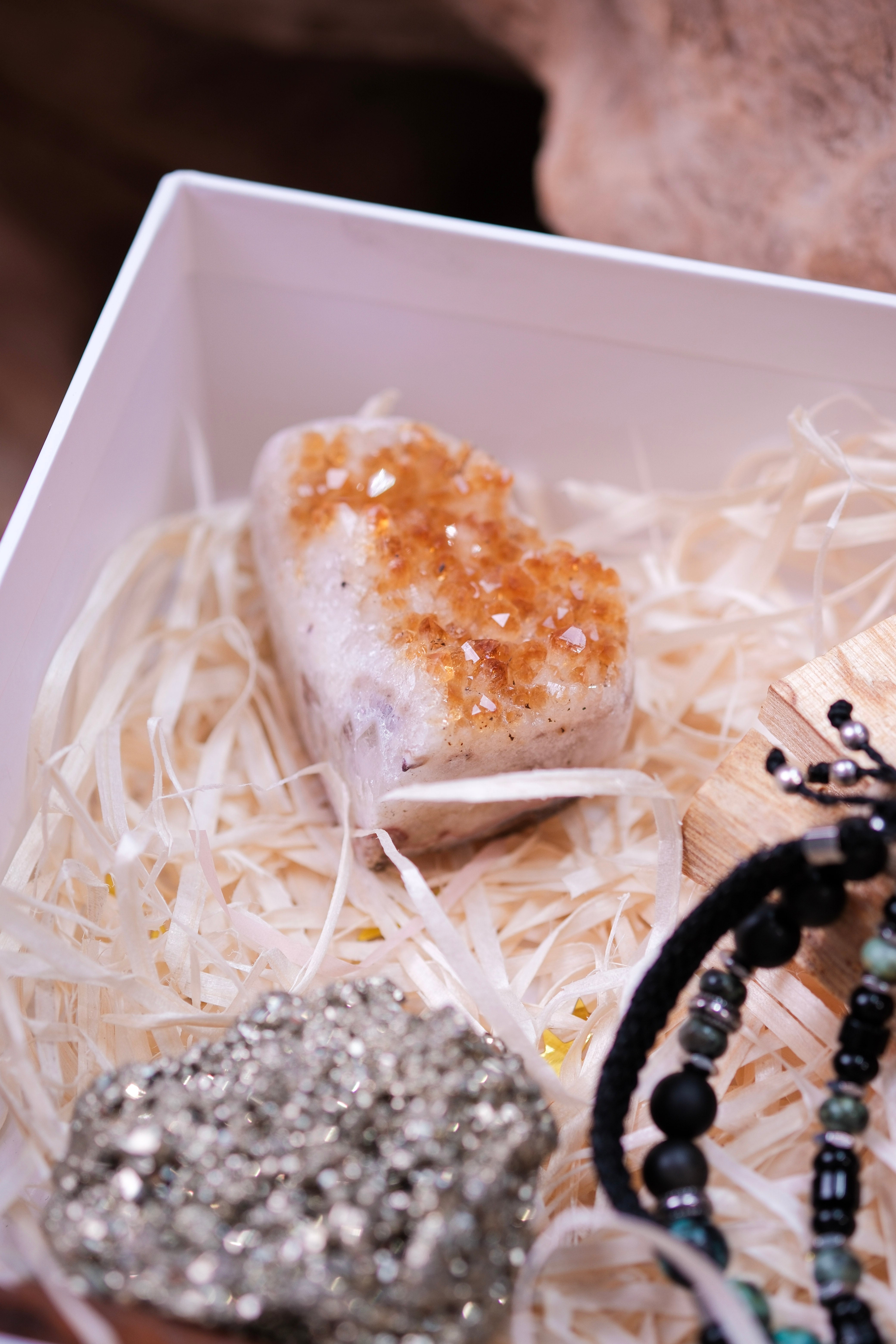 Luxury Christmas gift box with crystals and treasures displayed on delicate straw packaging