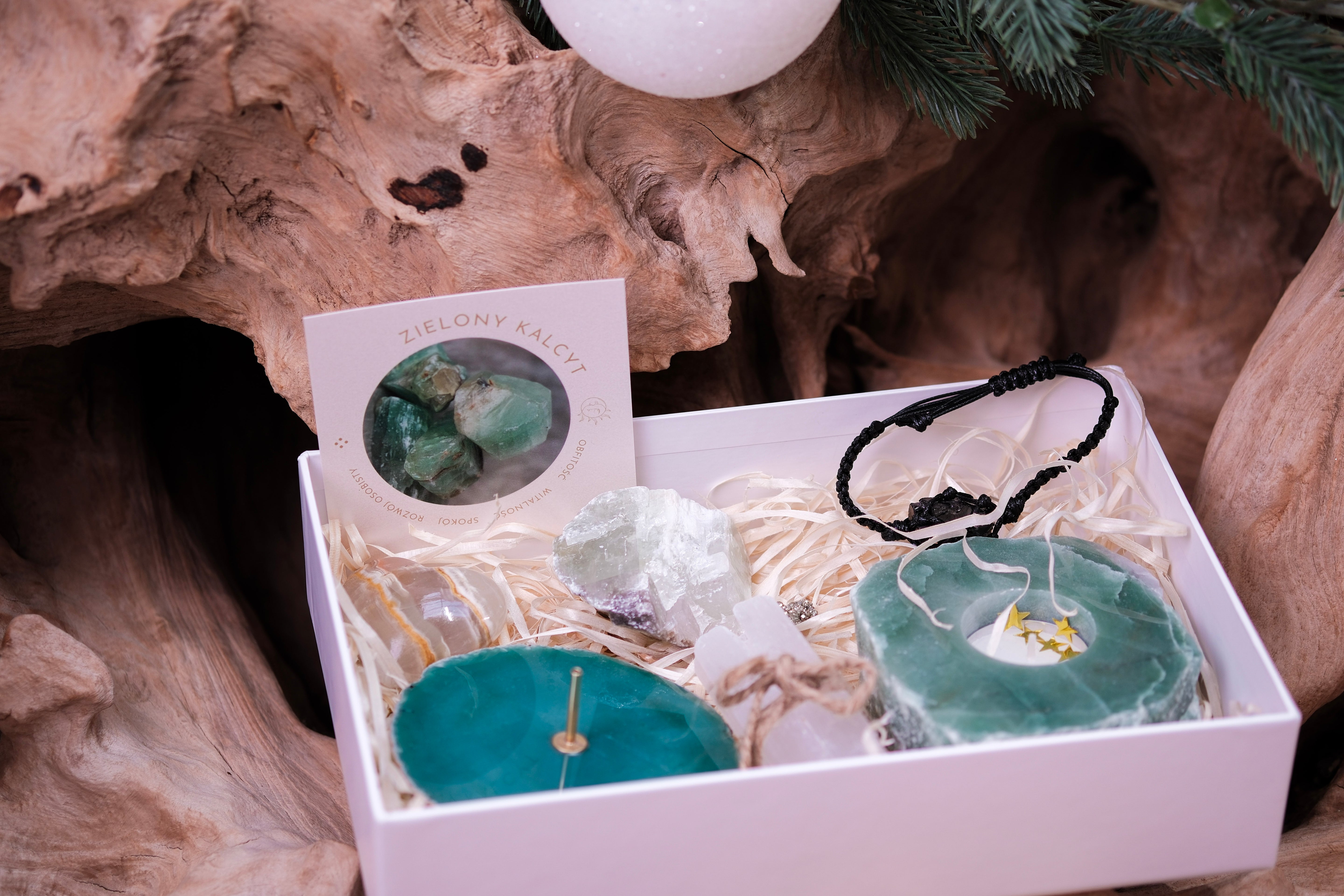 Christmas crystal gift set with teal crystals, bracelet, and decorative items in a box, set against a rustic wooden background.