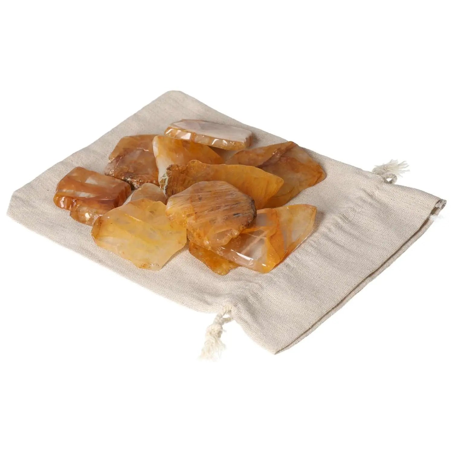 Hematoide Yellow Slice crystals on a beige pouch, symbolizing elegance and spiritual harmony, by Sylvia Crystals.