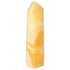 Yellow Mexican Calcite Obelisk by Sylvia Crystals, renowned for quality and spiritual significance, enhancing self-confidence and growth.