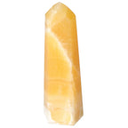 Elegant Mexican Calcite Obelisk from Sylvia Crystals, enhances aesthetics and spiritual well-being, promoting confidence and focus.