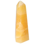 Yellow Mexican Calcite Obelisk from Sylvia Crystals, symbolizing positivity and motivation, enhances self-confidence and goal achievement.