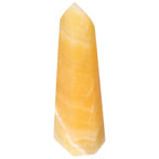 Mexican Calcite Obelisk from Sylvia Crystals, yellow crystal known for boosting confidence and motivation, isolated on white background.
