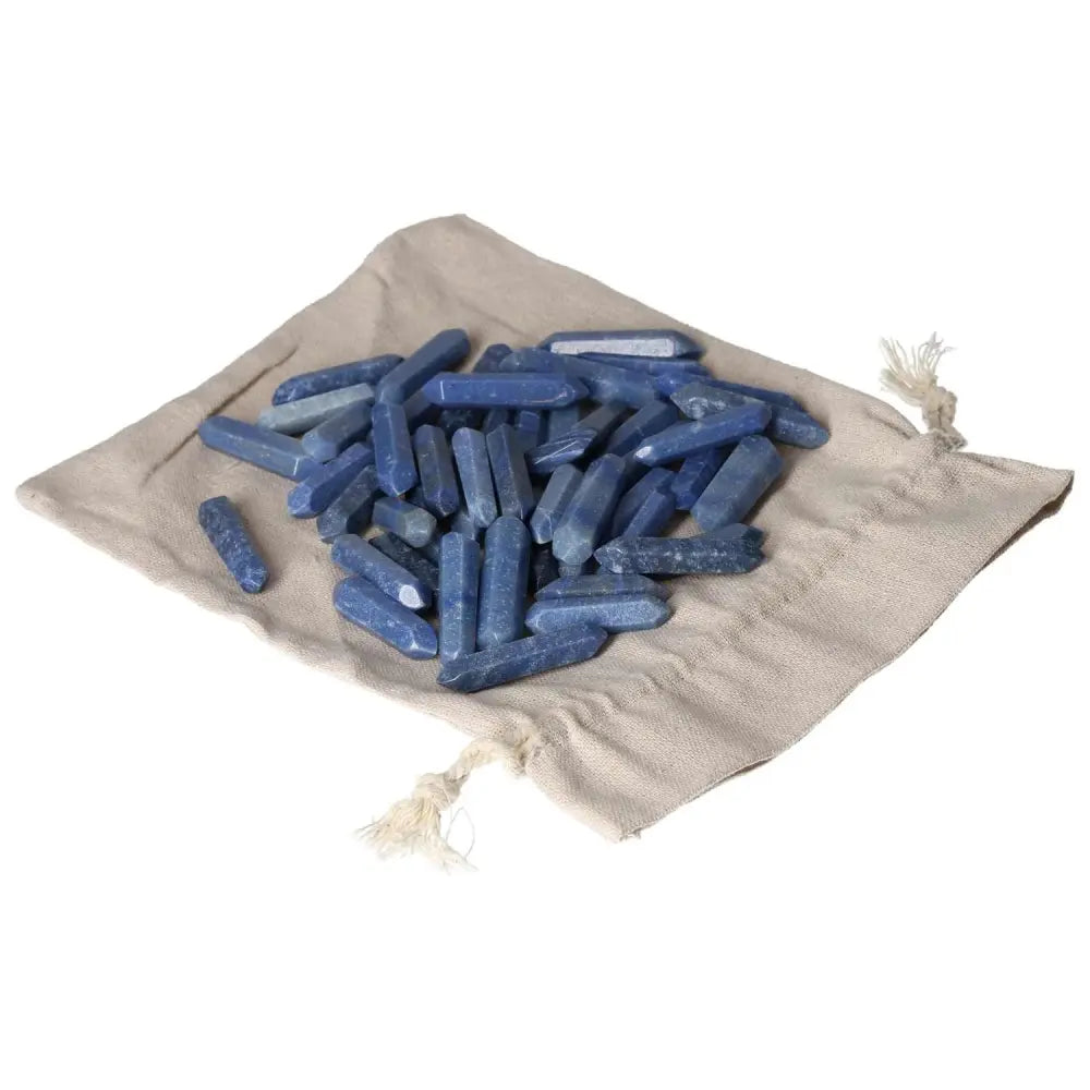 Blue Aventurine small sticks on a beige cloth, symbolizing spiritual transformation and mystical properties for personal awakening.