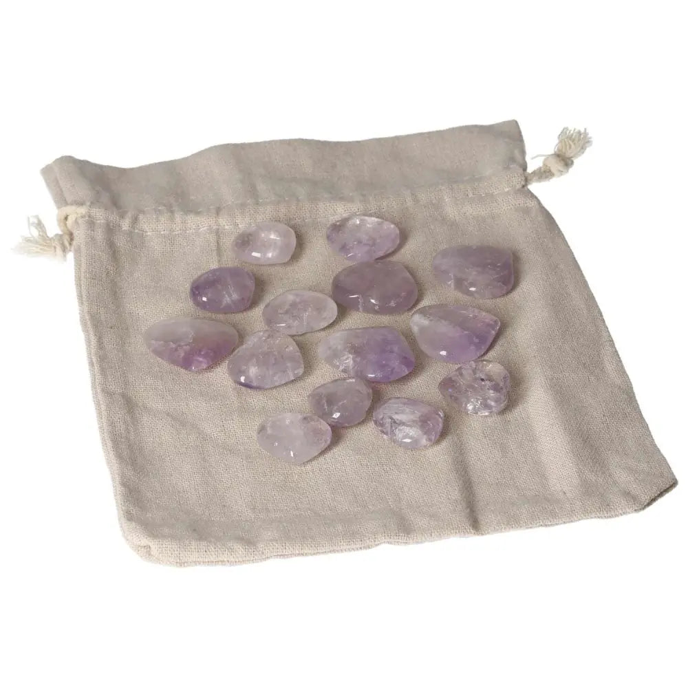 Collection of small amethyst heart stones laid on a cloth pouch, known for stress reduction and enhancing concentration and emotional stability.