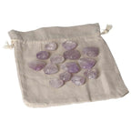 Collection of small amethyst heart stones laid on a cloth pouch, known for stress reduction and enhancing concentration and emotional stability.