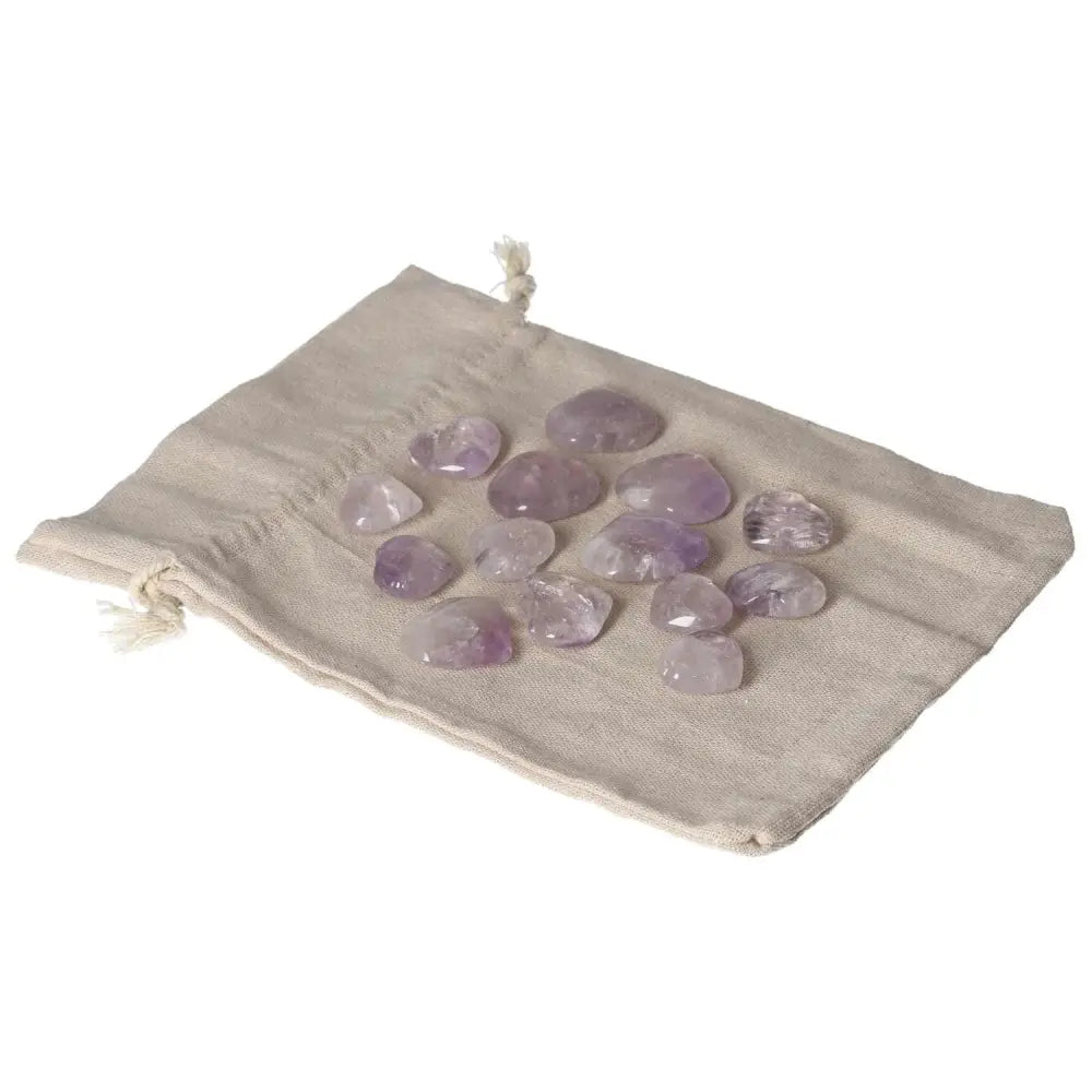 Small amethyst heart stones on a fabric bag, known for reducing stress and enhancing concentration.