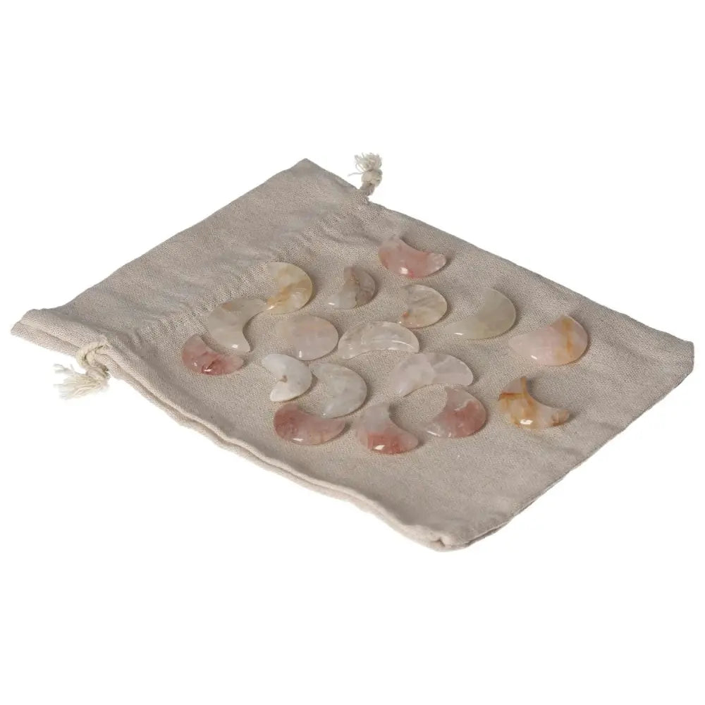 Set of small golden healer moon crystals displayed on a beige cloth pouch.
