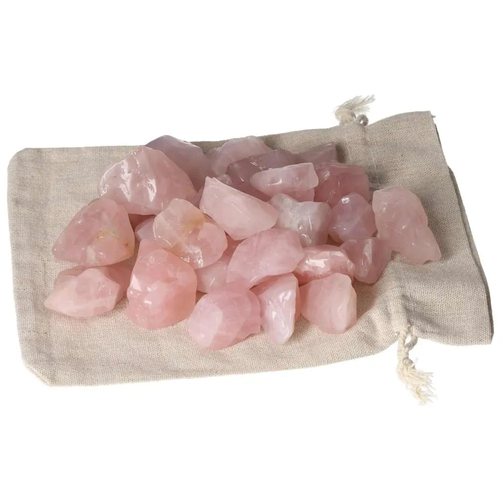 Tumbled Rose Quartz from Sylvia Crystals, featuring pink stones on beige cloth, symbolizing love and emotional healing.