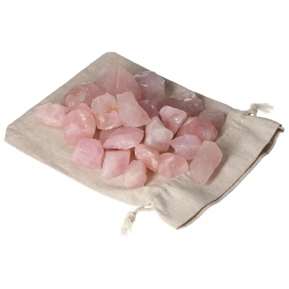 Tumbled Rose Quartz stones on a linen pouch, promoting emotional healing and love, from Sylvia Crystals collection.