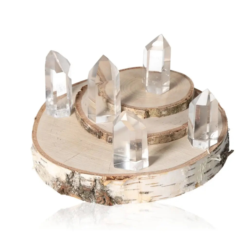 Clear crystal quartz points on a wooden display, showcasing natural clarity and vibrational energy for spiritual collections.