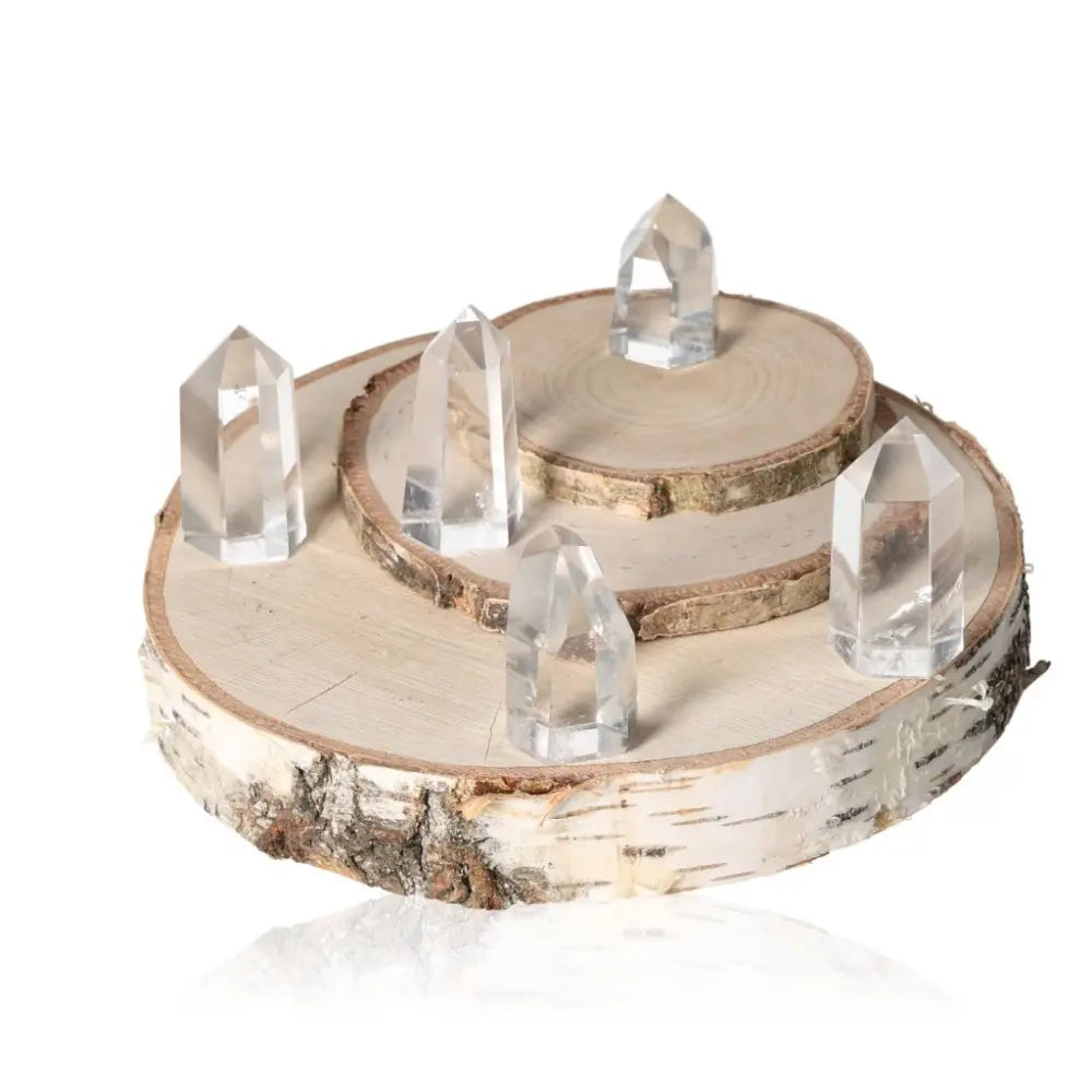 Clear Crystal Quartz Points displayed elegantly on a wooden base, highlighting their natural clarity and spiritual significance.