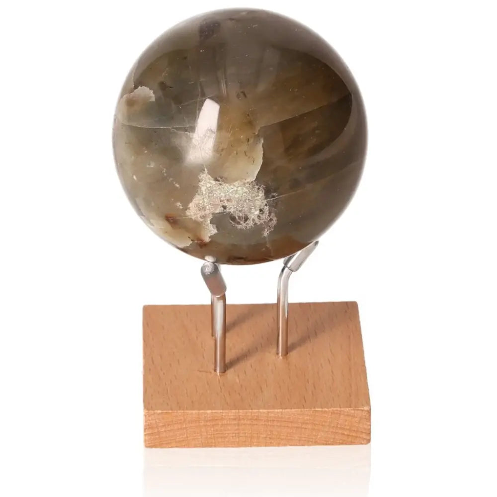 Garnierite sphere on a wooden stand, symbolizing prosperity, emotional balance, heart-centered healing, and personal growth.