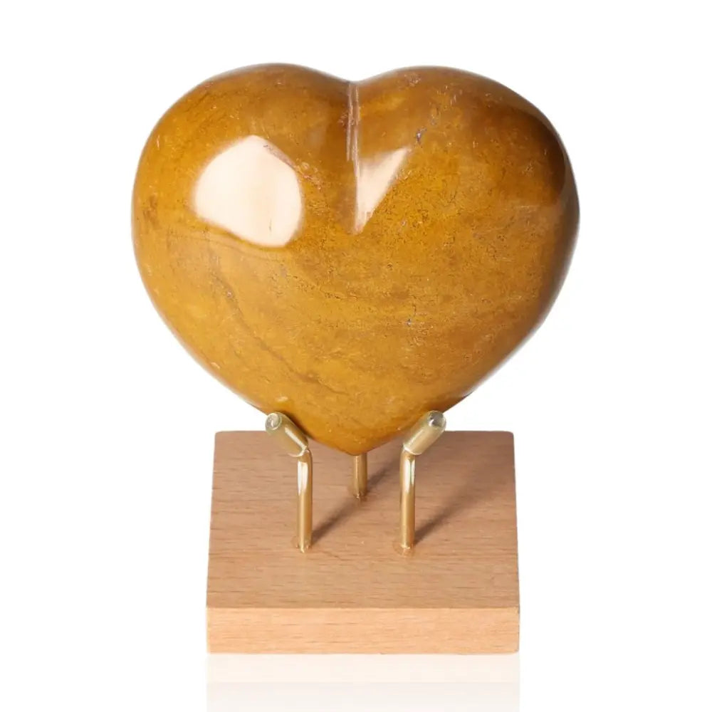 Golden Quartz Heart crystal known as Golden Healer Quartz, enhancing spiritual healing and divine connection on wooden stand.