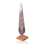 Natural Amethyst Point gemstone with soothing purple hues on a wooden base, known for stress reduction and energy enhancement.