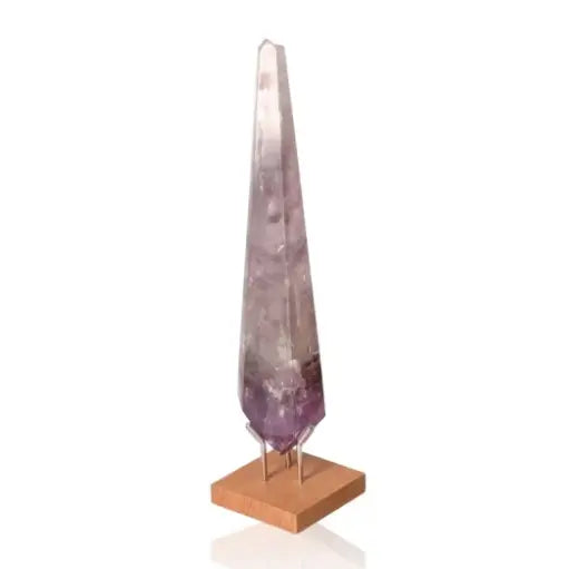 Natural Amethyst Point gemstone with soothing purple hues on a wooden base, known for stress reduction and energy enhancement.