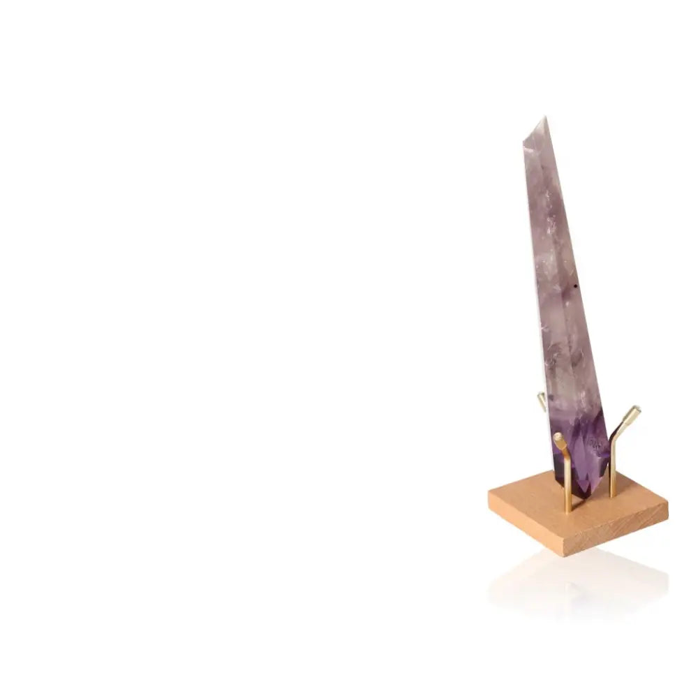 Natural Amethyst Point on wooden stand, showcasing its vibrant purple hues and spiritual connection to the crown chakra.