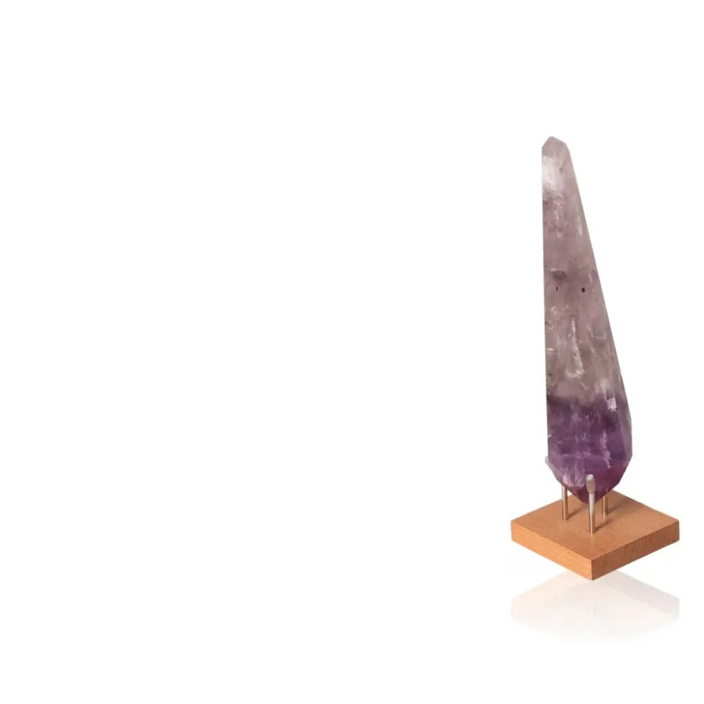 Natural Amethyst Point gemstone on wooden stand, deep purple hues, promotes spiritual enlightenment and chakra balance.