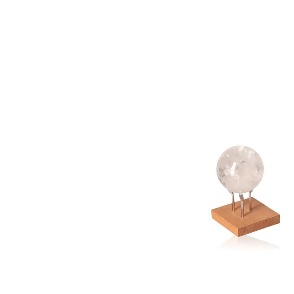Elegant Lemurian Quartz Sphere on a wooden stand, embodying spiritual depth and tranquility from Sylvia Crystals.