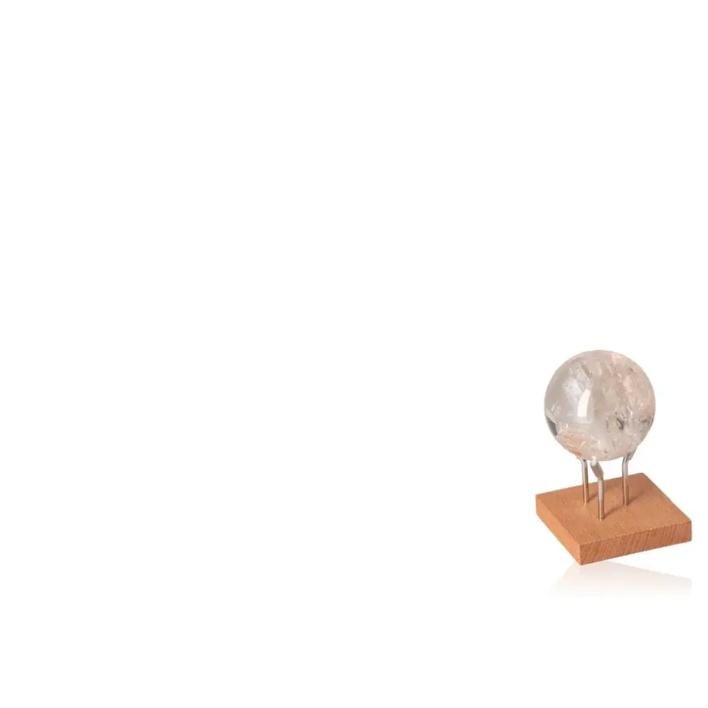 Lemurian Quartz Sphere displayed on a wooden stand, known for its clarity and spiritual potency in enhancing serenity and balance.