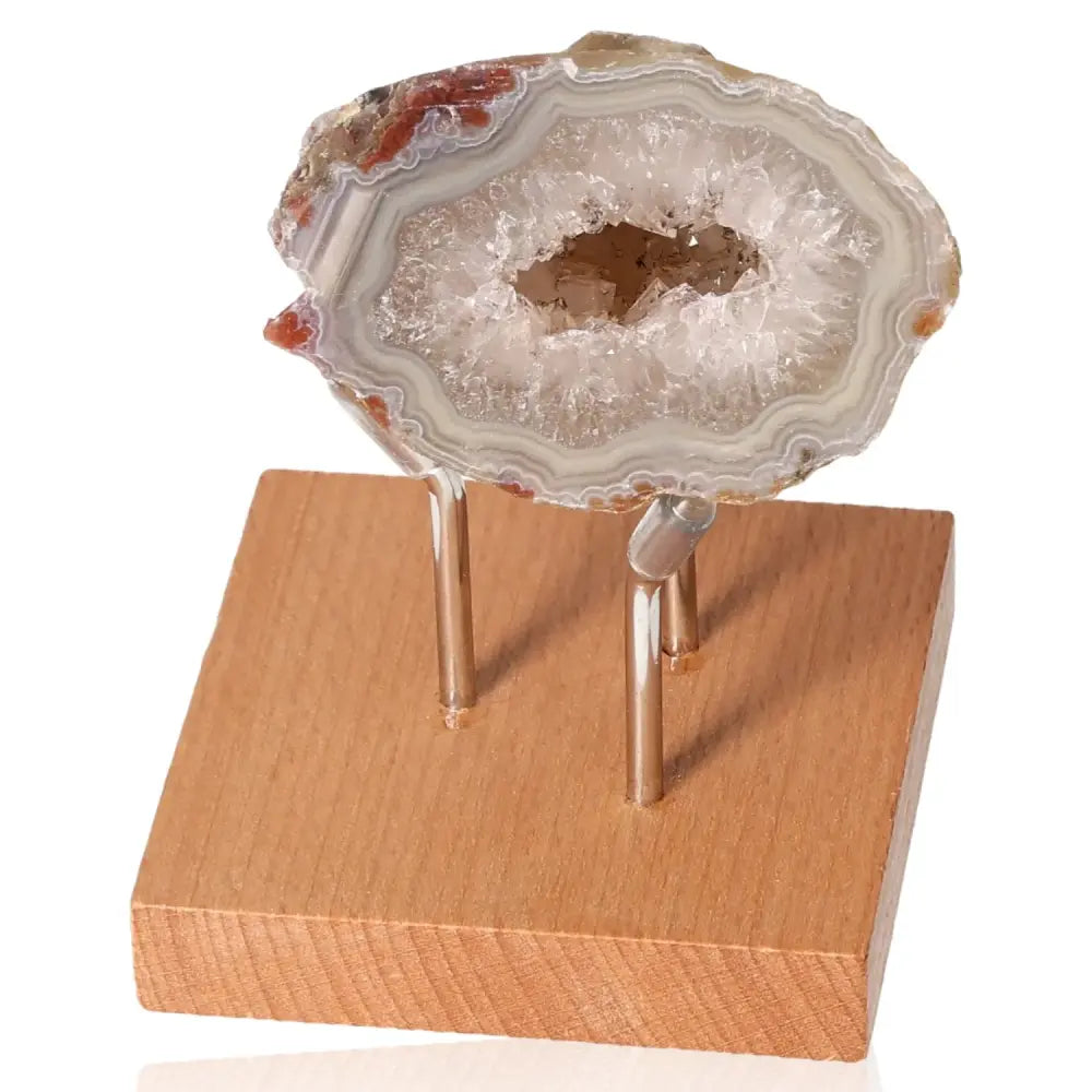 Mini Agate Geode on wooden stand, showcasing its intricate crystal formations for energy harmony and calming effects.