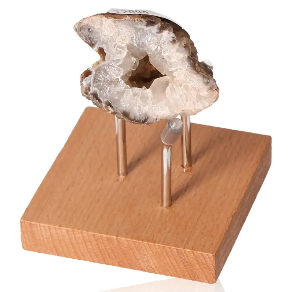Mini Agate Geode on a wooden stand, showcasing its crystal interior, known for harmonizing energy and enhancing tranquility.
