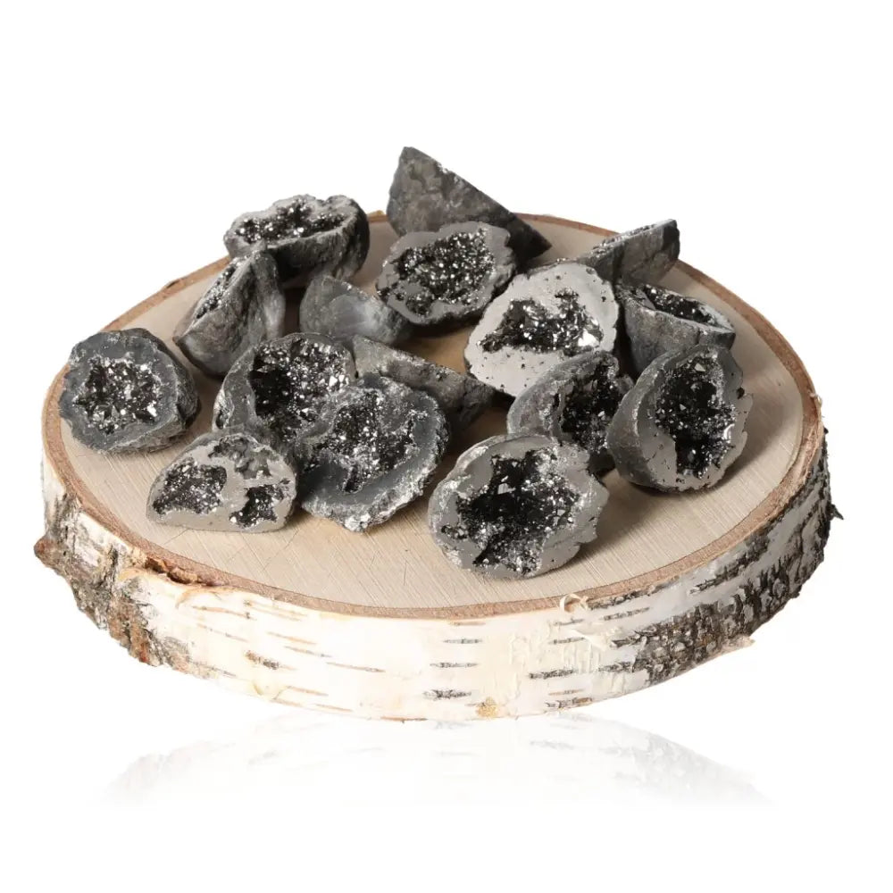 A collection of colored mini agate geodes displayed on a round wooden slice, showcasing the raw beauty and natural sparkle of the stones.