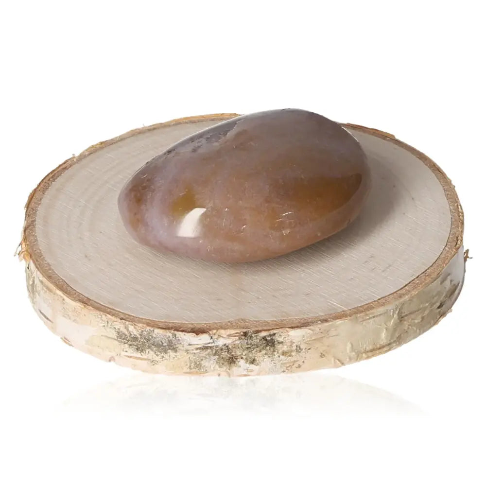 Polished banded agate tumbled stone on wooden base for energy balance and tranquility