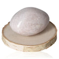 Smooth tumbled jasper stone on wooden slab promoting calmness and serenity