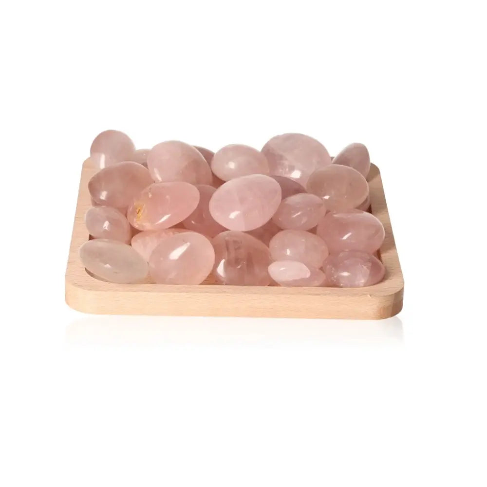 Rose Quartz Palm Stones on a wooden tray, featuring smooth, pink crystal pieces ideal for healing and meditation purposes