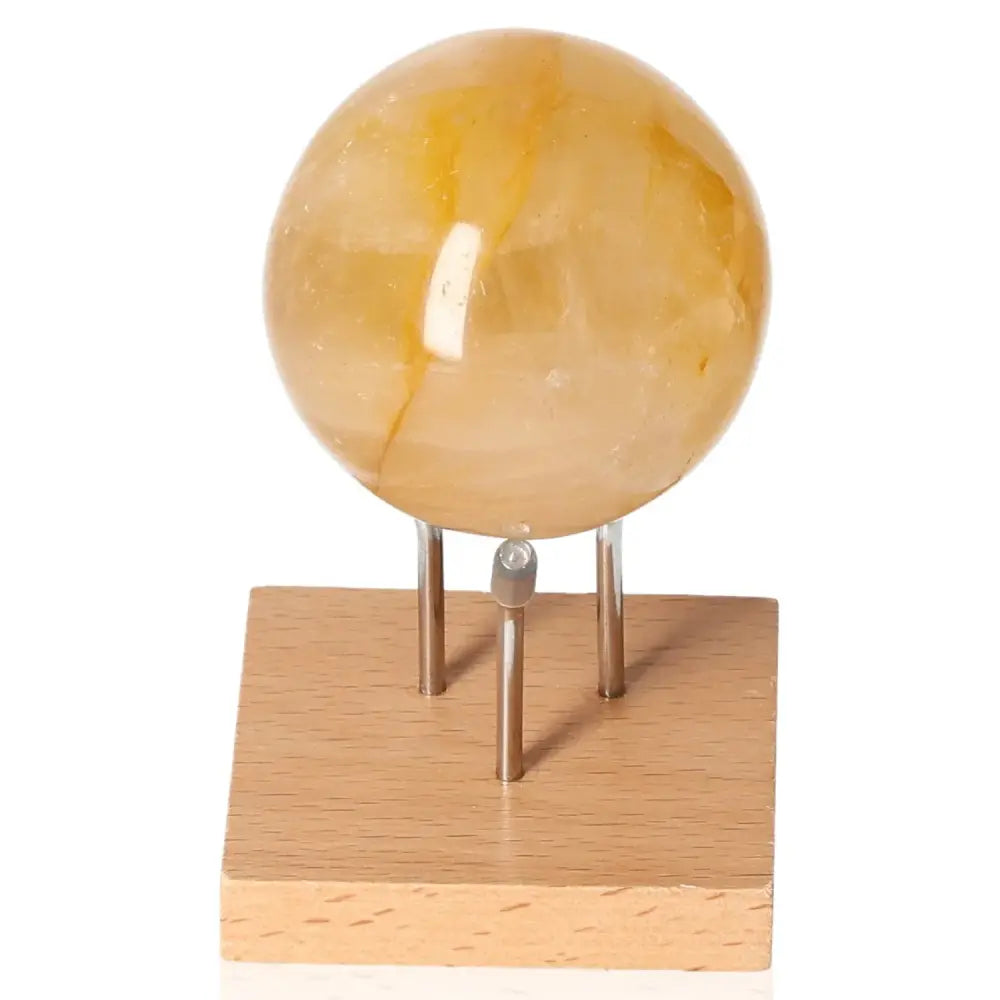Honey Calcite Quartz Sphere on wooden stand, symbolizing confidence and clarity, perfect for enhancing focus and motivation.