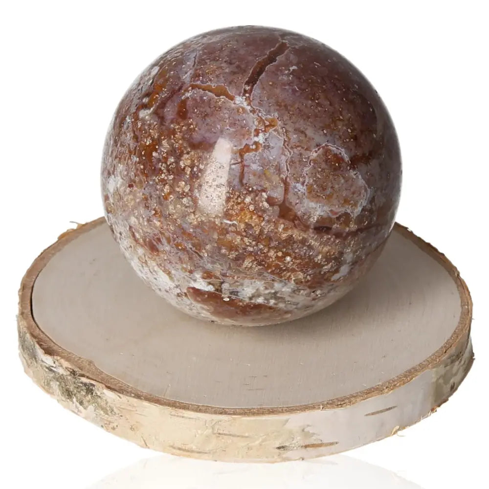 Ocean Jasper Sphere on wood slab, promoting joy and tranquility with its serene energy and captivating beauty. Ideal for emotional balance.