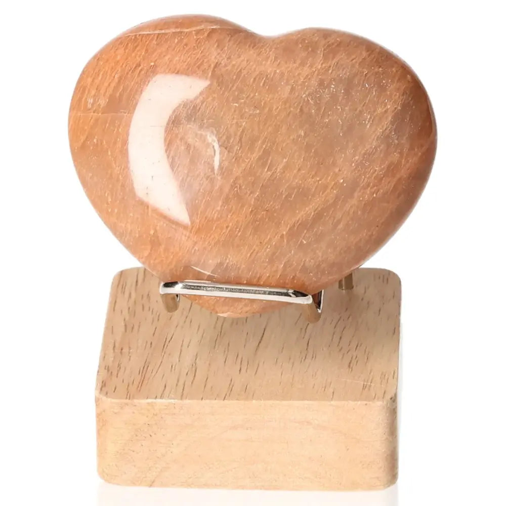 Peach Moonstone Heart on wooden stand, enhances emotional balance, intuition, and protects against nightmares, not including stand.