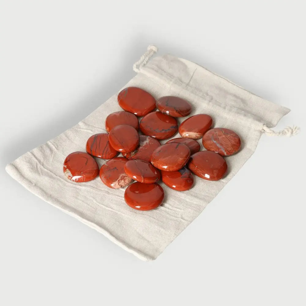 Collection of polished Jasper Palm Stones in a white drawstring bag for tranquility and balance.