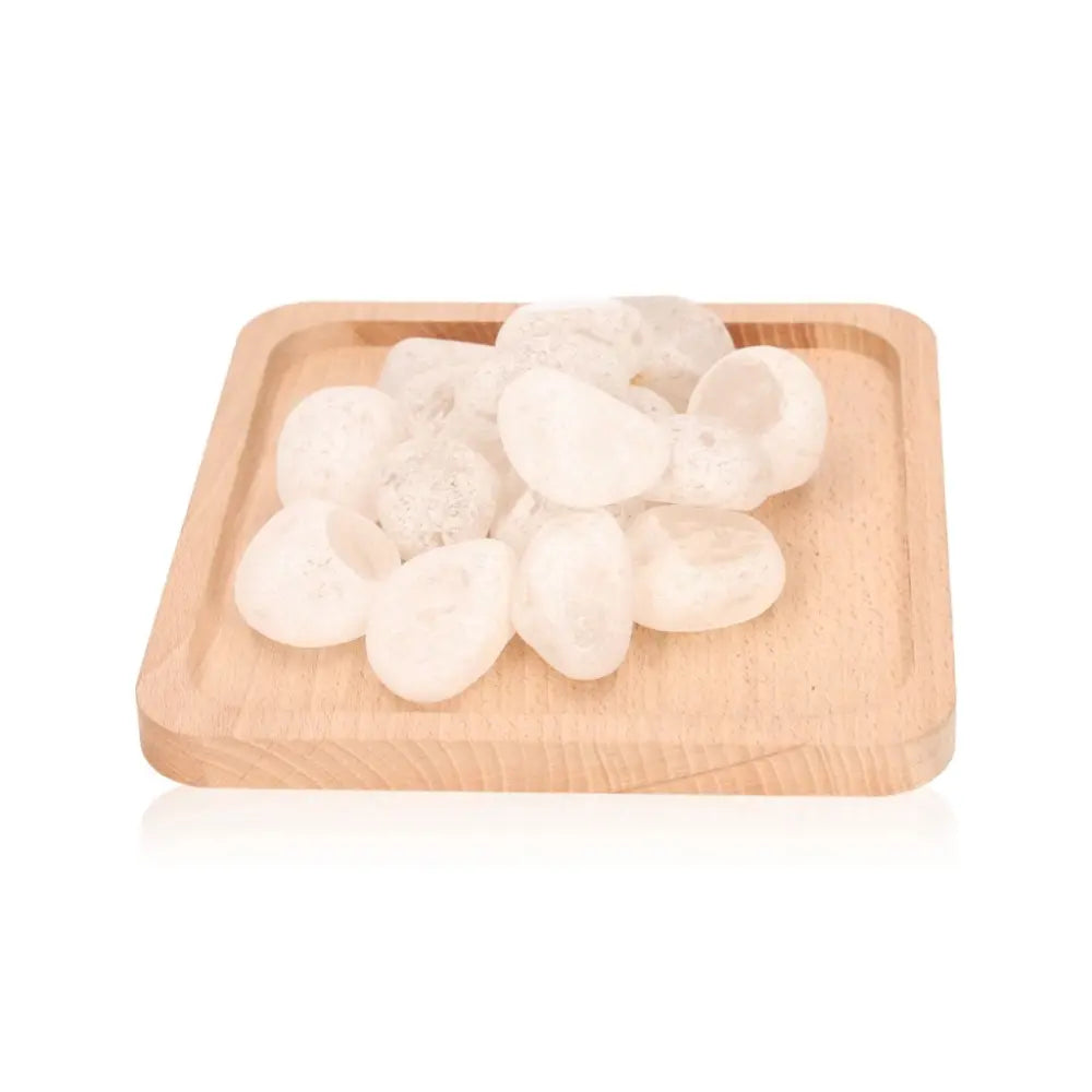 Natural Emma Eggs stones on a wooden tray, showcasing smooth, polished river stones from New Zealand promoting balance and harmony.