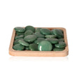 Wooden tray with polished green aventurine palm stones arranged neatly for display.
