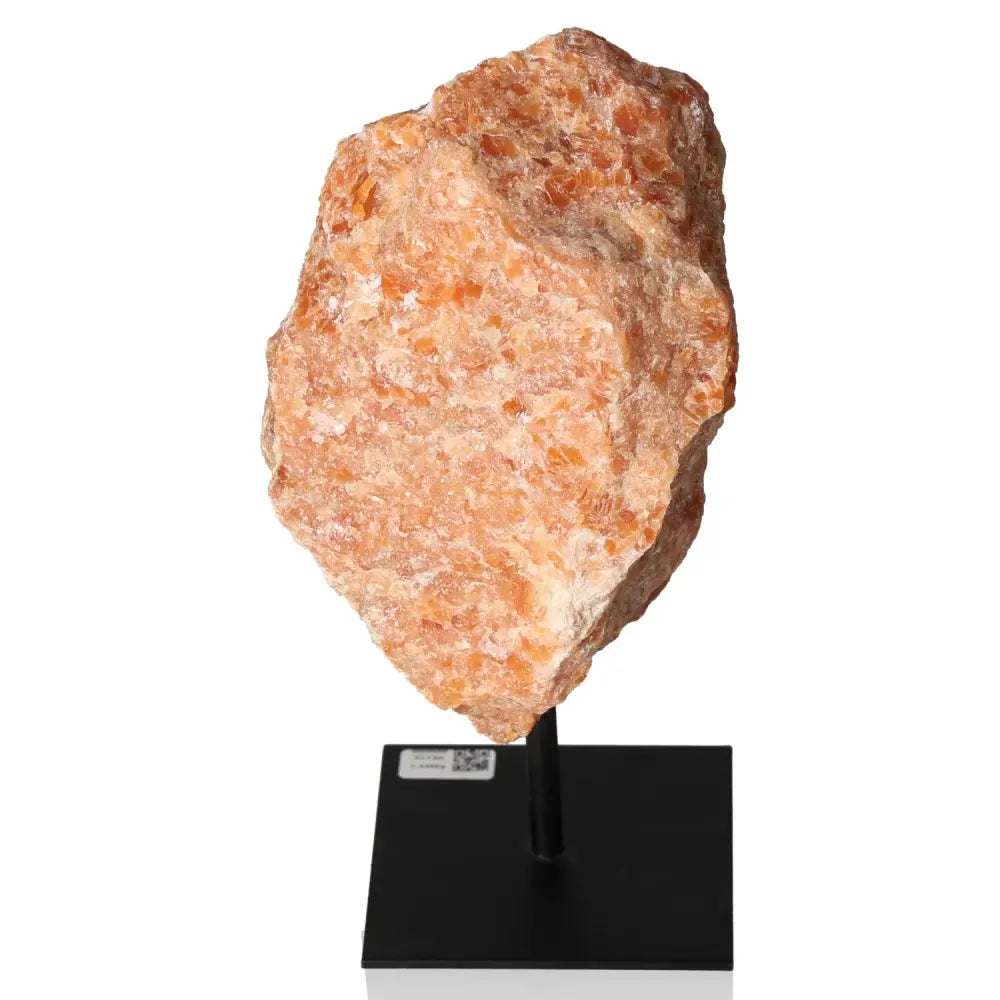 Orchid Calcite gemstone on metal stand, showcasing vibrant orange and pink tones for creativity and emotional strength enhancement.