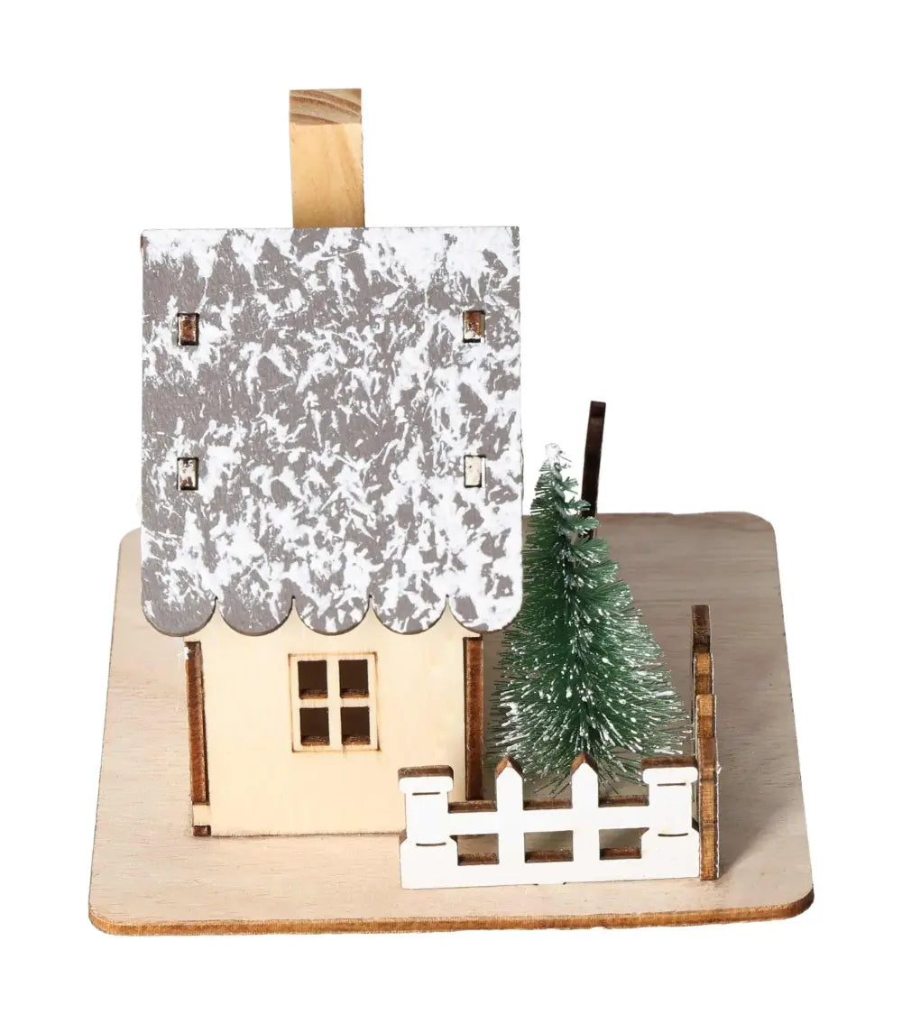 Table Deco House LED with snow-dusted roof and evergreen tree, embodying luxury and tranquility.