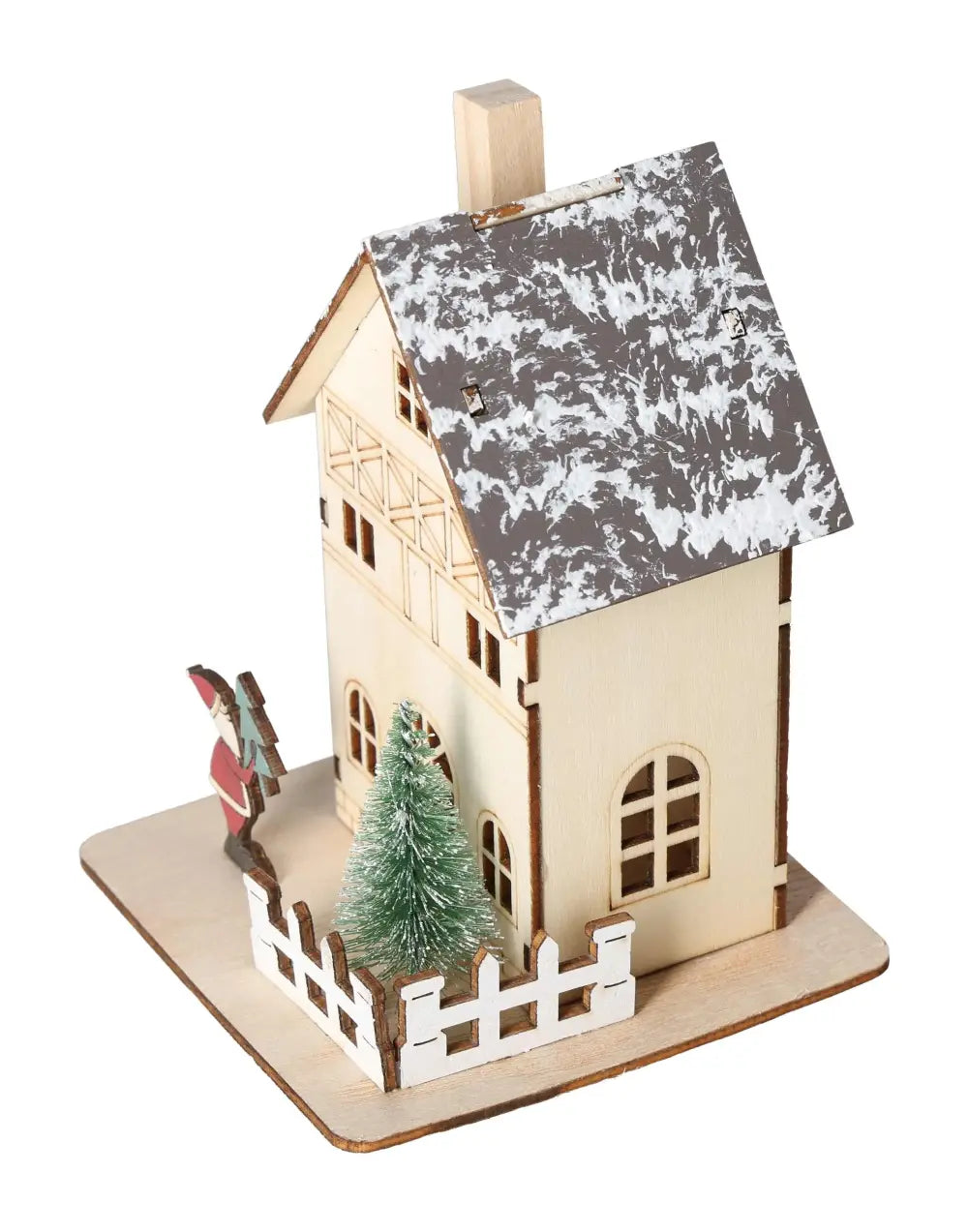Wooden table decoration in the shape of a house, featuring a snow-covered roof, small Christmas tree, and festive figurine.