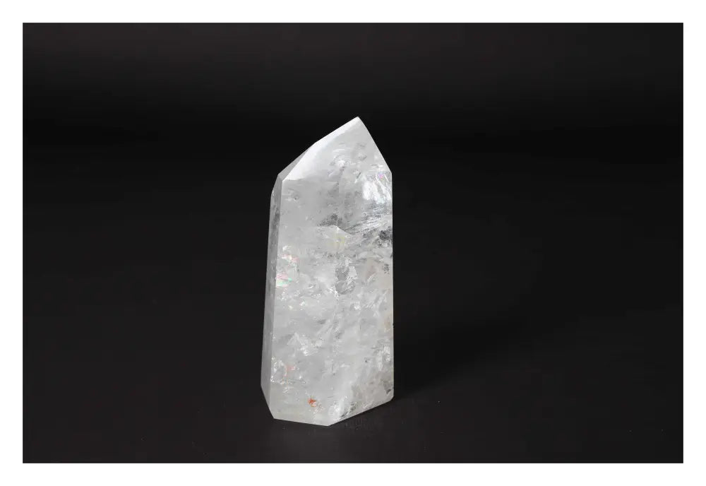 Clear Crystal Quartz Point on a black background, showcasing its clarity and spiritual energy; ideal for beauty and growth.